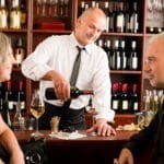 Wine bar senior couple enjoy drink professional barman pour glass