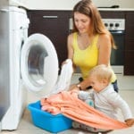 Family woman putting clothes in to washing machine