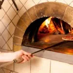 kucharz piecze pizze