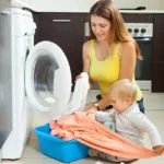 Family woman putting clothes in to washing machine